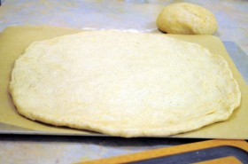 Transfer to a pizza peel (paddle) or a sheet pan lined with parchment paper