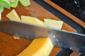Thinly slicing the cantaloupe wedges